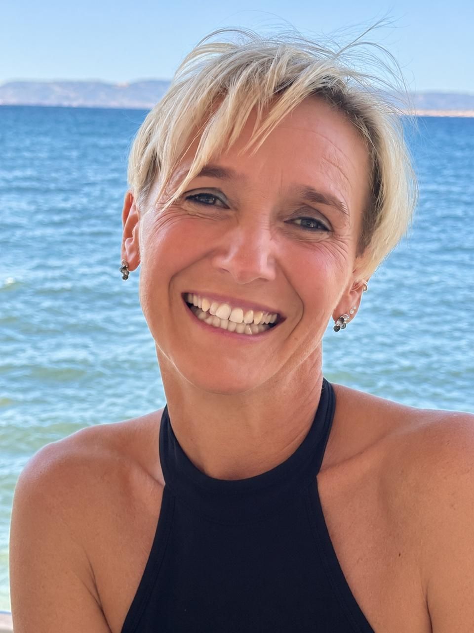Christiane Jahner lachend vor dem Meer